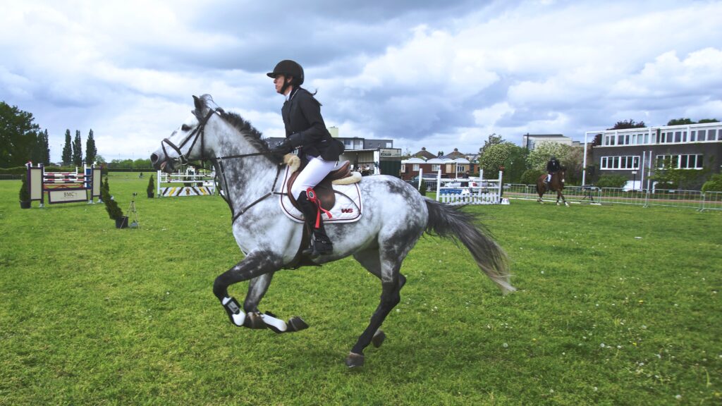 English rider cantering a dapple gray horse