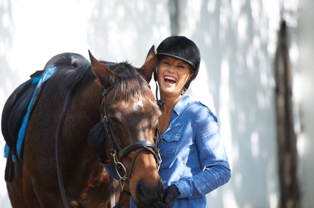 A girl in blue holding the horse she leases